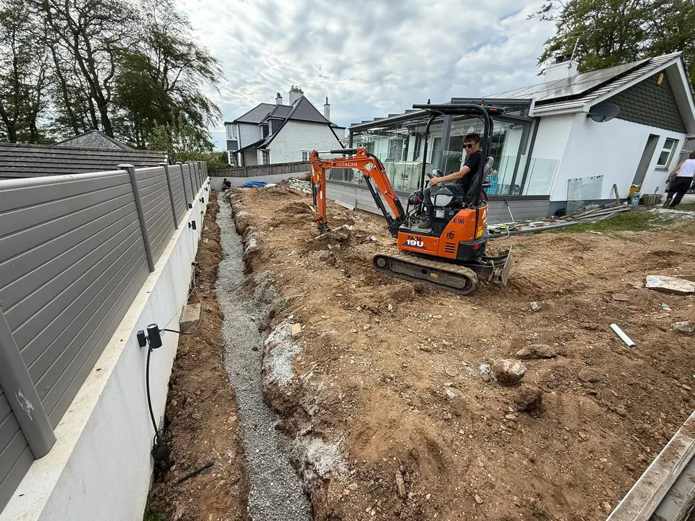 Mini digger working on groundworks in a Cornwall garden