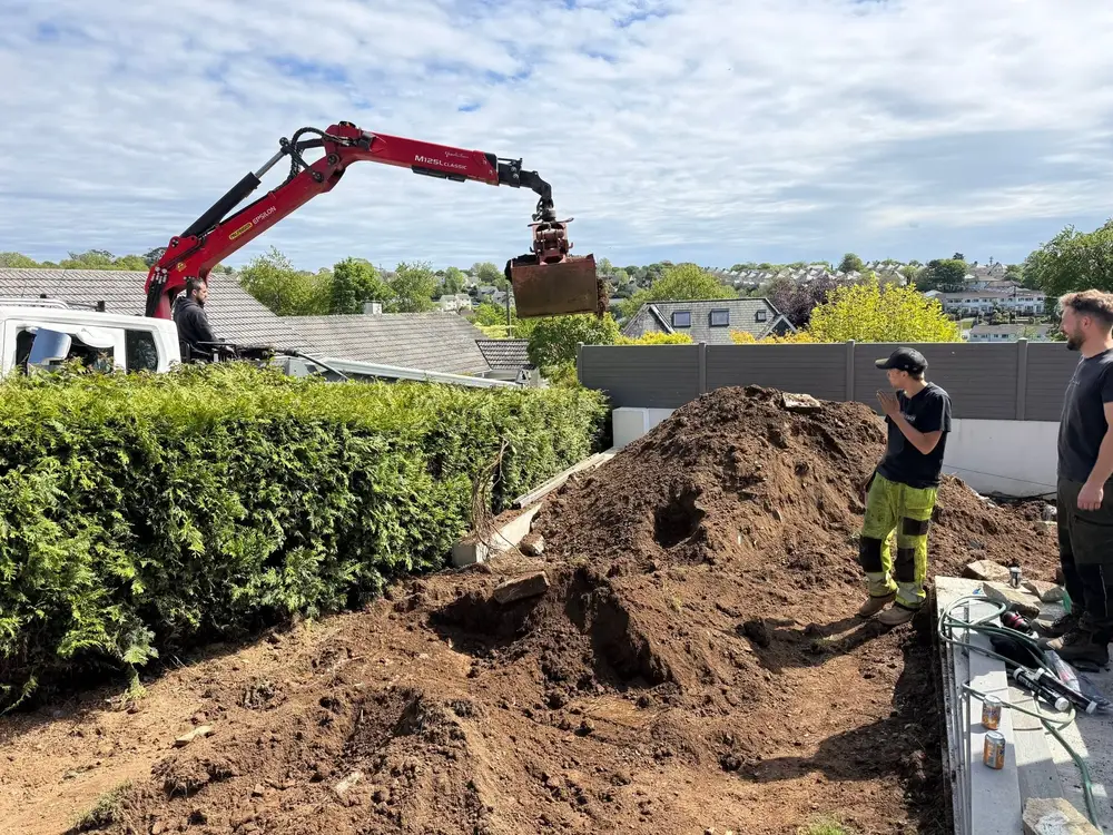 Grab lorry crane lifting soil during a garden clearance